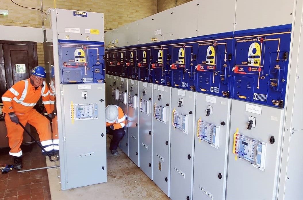 Engineers installing electrical equipment in room