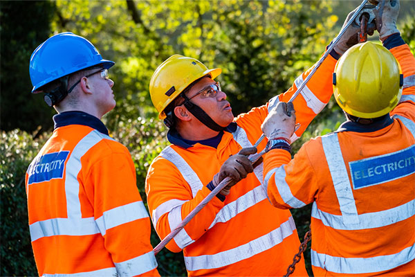 3 linesmen pulling a stay wire