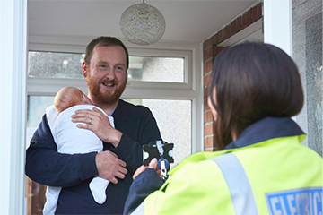 Image of SSEN engineer visiting young man with baby